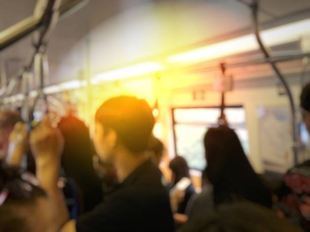 istock blurred image of people standing and sitting and passenger hand holding handle on the train of the public transport. interior abstract background. 968231890