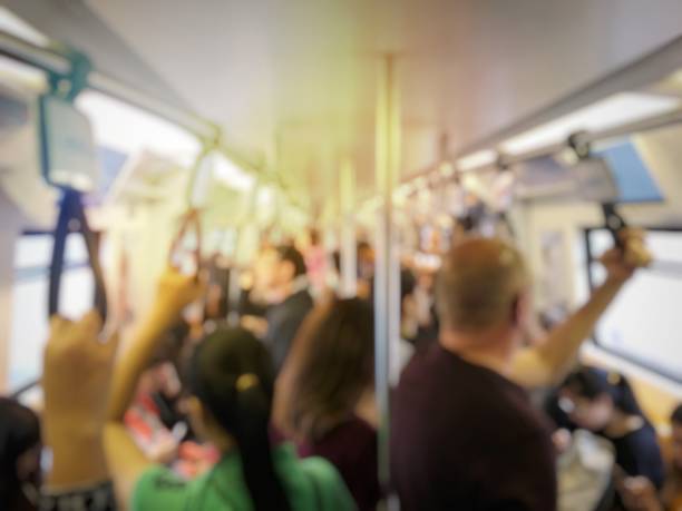 istock blurred image of people standing and sitting and passenger hand holding handle on the train of the public transport. interior abstract background. 968231920