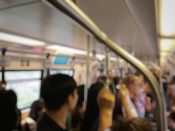 istock blurred image of people standing and sitting and passenger hand holding handle on the train of the public transport. interior abstract background. 968231938
