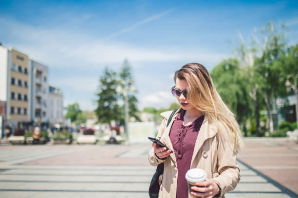 istock Woman walking in city square and using mobile phone. 968231976