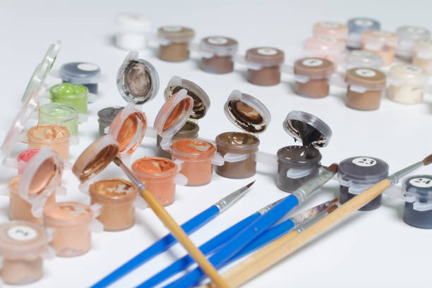 istock Watercolors and brushes on a white surface. Paints for drawing by numbers. Subjects for creativity. 968235286