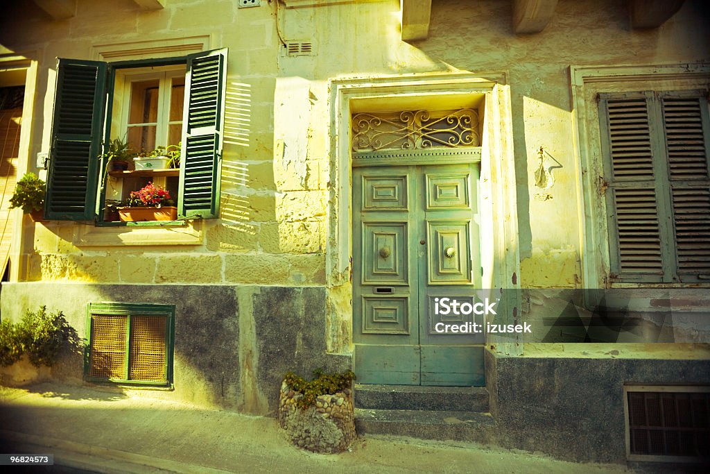 Windows and door A picturesque street with ornate door and open window  shutters. Architecture Stock Photo