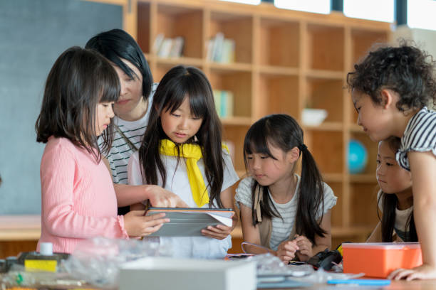 istock Teacher showing young group of students something on a digital tablet 968253856