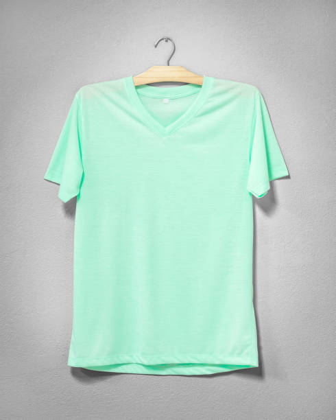istock Green shirt hanging on cement wall. Empty clothing for design. Front view. 968256918
