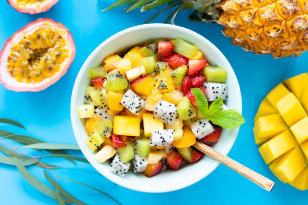 istock Fruit salad with tropical and exotic fruits on blue background 968256986