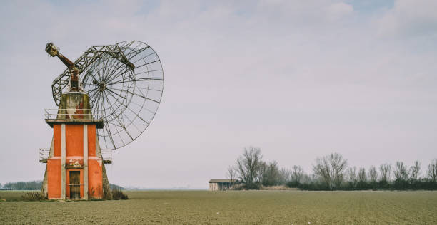 Retro future: broken and abandoned radio telescope. Retro future: broken and abandoned radio telescope in the plain of the Po valley near to Bologna, Italy. parabola stock pictures, royalty-free photos & images
