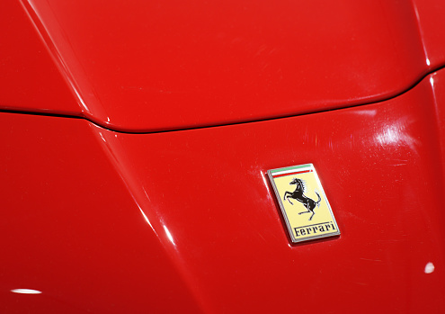 Maranello, Italy - April 27, 2015: Ferrari logo on red car bonnet. This is older type logo used on Ferrari cars between 1961 and 1989.