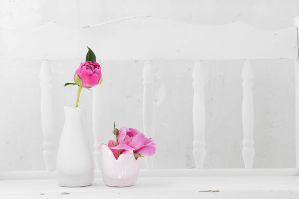flowers in vase on white wooden shelf