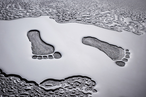dry traces of human feet in a pool of water. conceptual photo
