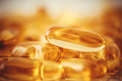 Close up vitamin D and Omega 3 fish oil capsules supplement  for good brain , heart and health eating benefit