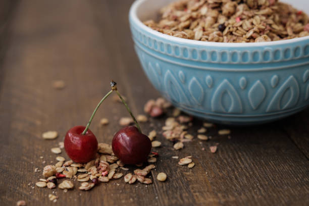 Blue Bowl of homemade Granola baked with nuts  on wooden background