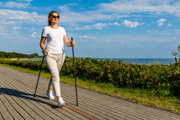 ノルディックウォー キング-女性の海辺でトレーニング - nordic walking walking relaxation exercise women ストックフォトと画像