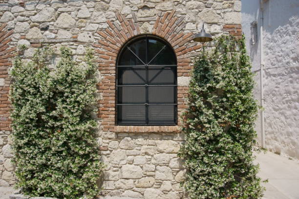 Arch shaped iron framed window of a stone brick house