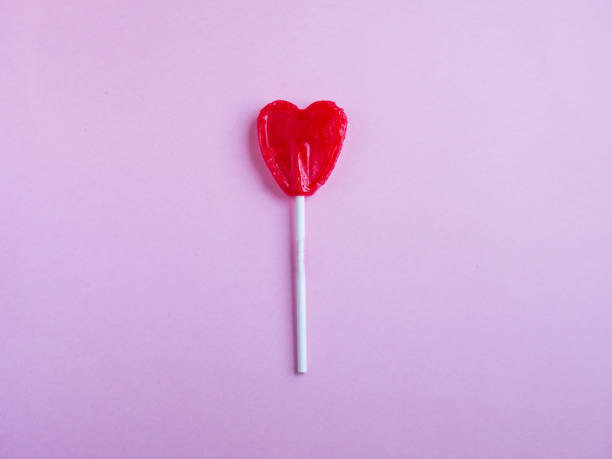 istock Red heart lollipop on pink background 968275984