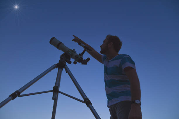 istock Man looking at the stars with a telescope. 968279248