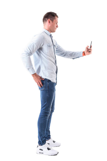istock Side view of content adult man holding and using smart phone 968279364