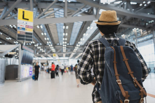 istock back view Asian man tourist in airport. 968282978