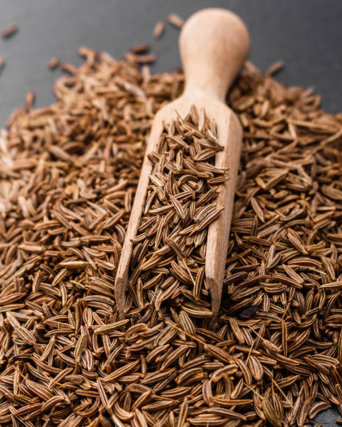 istock Seeds of cumin on a dark stone background 968285456