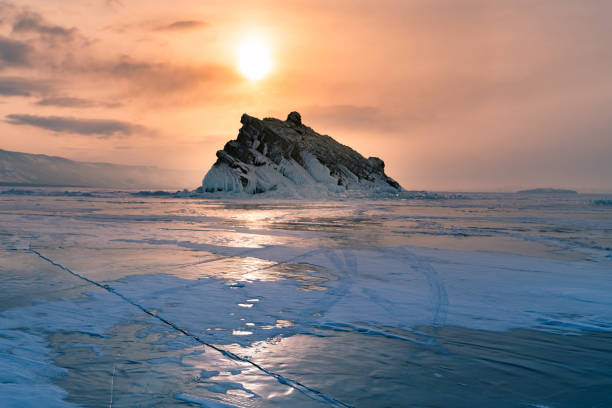 istock Frozen water lake Baikal Russia with sunset 968286476