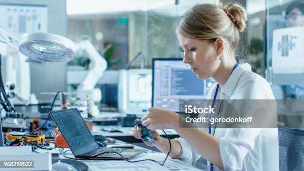 Female Computer Scientists Connects Circuit Board To Her Laptop And Starts Programming It She Works In The Technologically Advanced Laboratory Stock Photo - Download Image Now