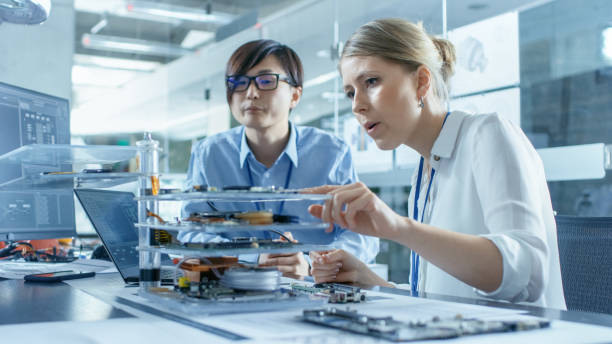 istock Two Computer Engineers Choose Printed Circuit Boards to Work with. In The Background Technologically Advanced Scientific Research Center. 968289552