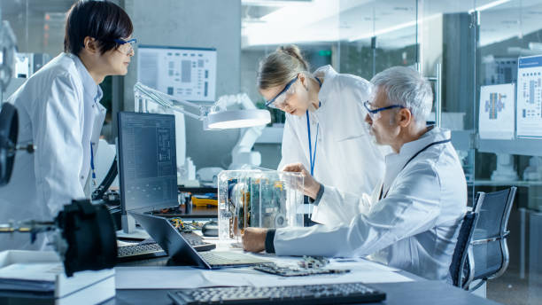 istock Team of Scientists Choose Between Printed Circuit Board to Work With. In The Background Technologically Advanced Scientific Research Center. 968289588