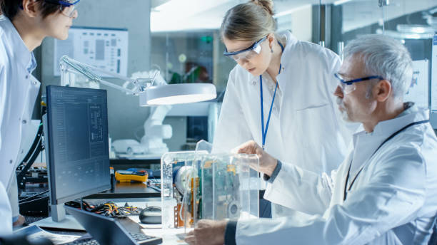 istock Team of Scientists Choose Between Printed Circuit Board to Work With. In The Background Technologically Advanced Scientific Research Center. 968289604