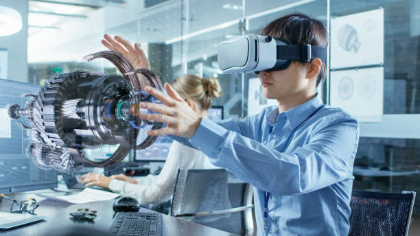 ingeniero en informática llevando obras de auricular de realidad virtual con visualización en 3d modelo del holograma, hace gestos. en la oficina de ingeniería de fondo con compañeros de trabajo ocupados. - realidad aumentada fotografías e imágenes de stock