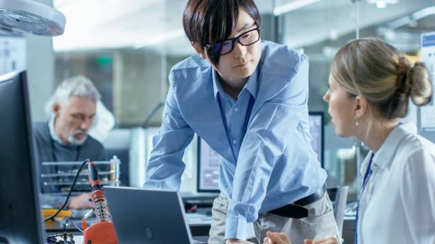 istock Female Computer Scientists Connects Circuit Board to Her Laptop with Mock-up Green Screen. She Works in the Technologically Advanced Laboratory. 968289796