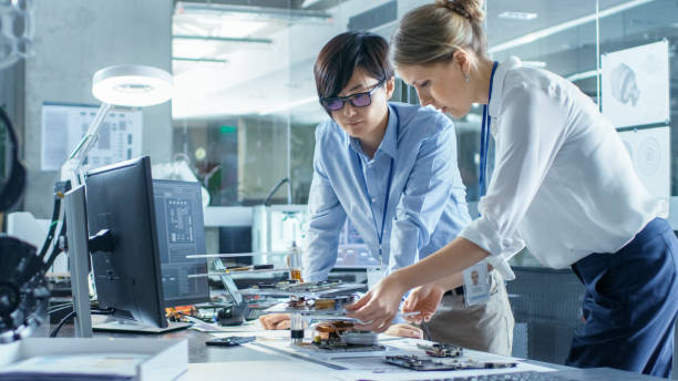 istock Two Computer Engineers Choose Printed Circuit Boards to Work with. In The Background Technologically Advanced Scientific Research Center. 968289836