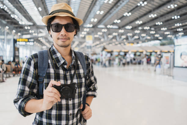 istock Asian man bag pack tourist with camera in airport. 968290180