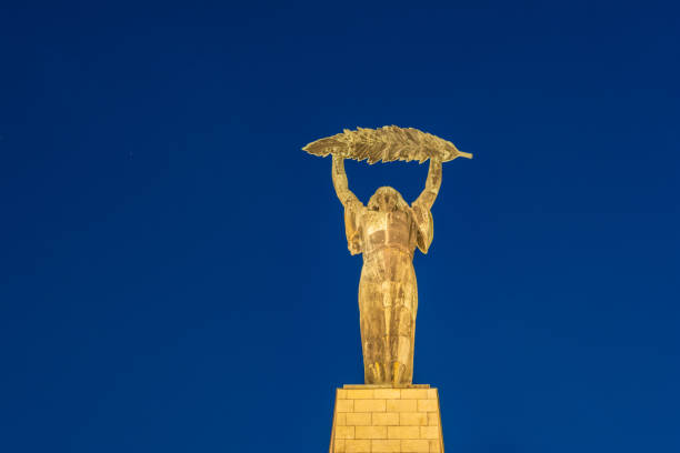 la estatua de la libertad o la estatua de la libertad en la noche en la colina gellert en budapest, hungría. se conmemora a aquellos que sacrificaron sus vidas por la independencia de hungría. - liberation monument budapest hungary monument fotografías e imágenes de stock