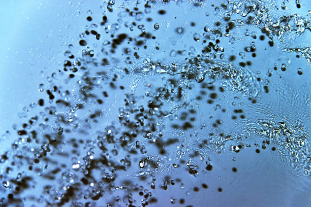 istock splashing water blue background. Frozen drops instant 968296574