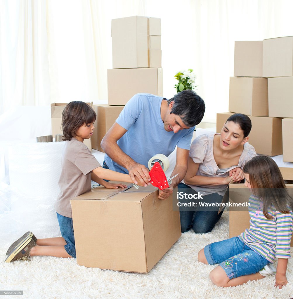 Jolly Family moving house Jolly Family moving house packing boxes Family Stock Photo