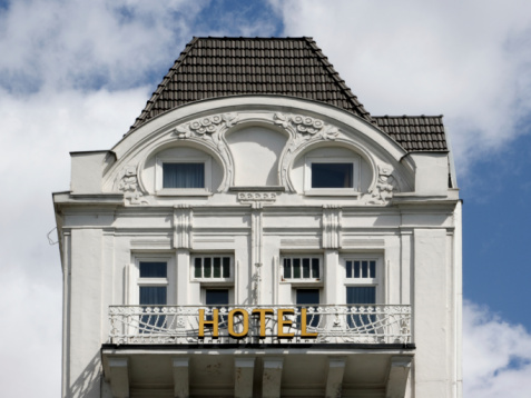 Sign with the word 'HOTEL' written in bright capital letters on the top of a building in Paris, France