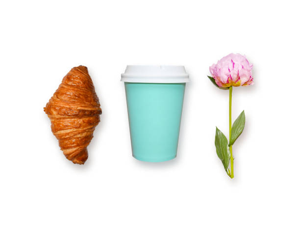 Fresh croissant, coffee take away and pink peony flower on white background, top view. Minimalistic flat lay concept of woman's breakfast dessert.