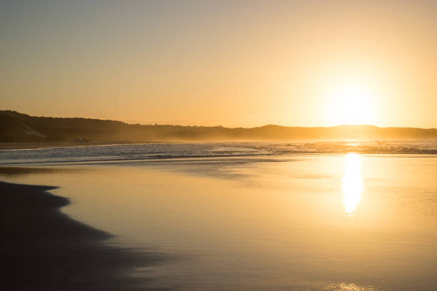 istock Orange sunset over the ocean from the beach shoreline 968309758