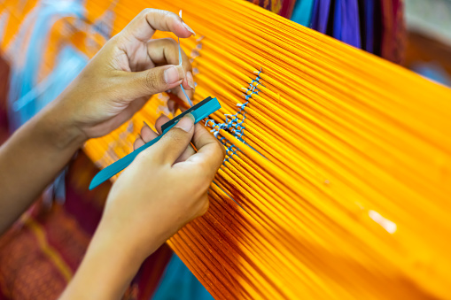 Asia Woman Procedure Making Thai Silk Pattern weaving in small weaving mill in Thailand
