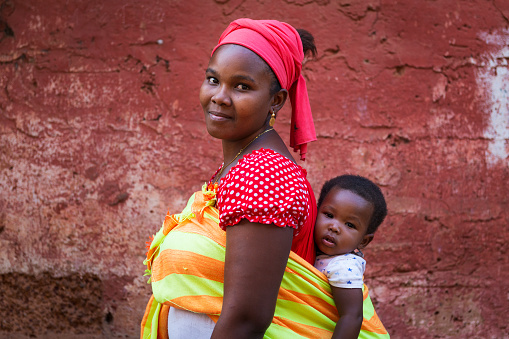 Bissau, Republic of Guinea-Bissau - January 31, 2018: Portrait of a mother and her baby daughter at the Cupelon de Cima neighborhood in the city of Bissau, Guinea Bissau.