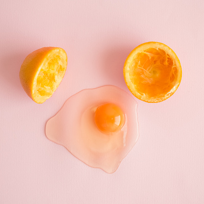 Orange fruit in form of broken egg minimal abstract creative concept.
