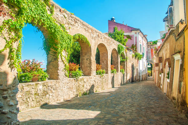 old european street with stone wall beautiful old stone wall with arches and flowers on old european street, Ravello, Amalfi coast, Italy ravello stock pictures, royalty-free photos & images