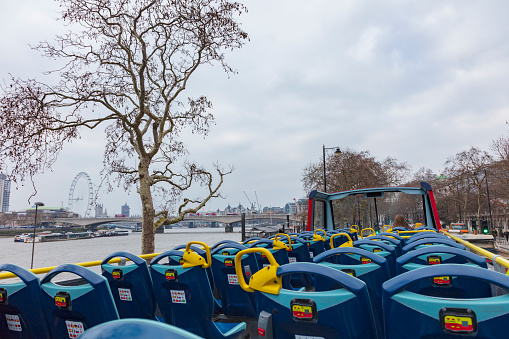 London, UK - Feb 22, 2018: Groupe of tourists enjoying the ride on an open-air double decker Tour Bus in London.