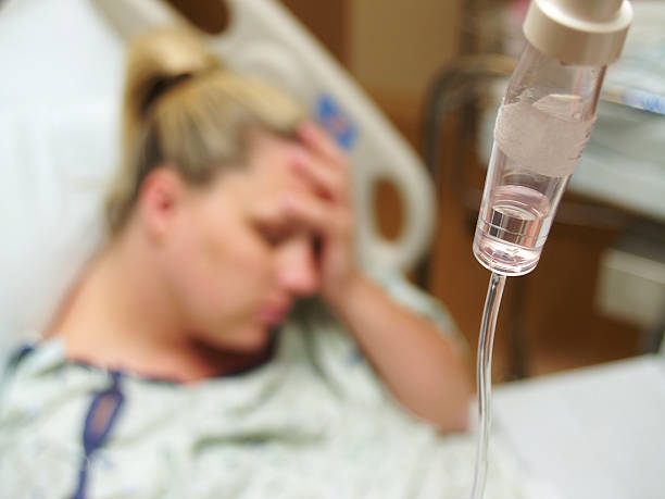 Hospital Patient a woman depressed in the hospital on an iv. hospital depression sadness bed stock pictures, royalty-free photos & images