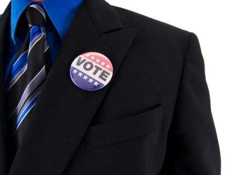 a business man in a suit as a voter isolated on white.