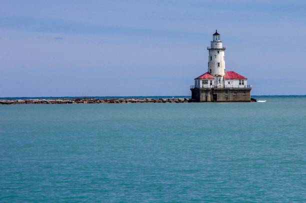 istock Red and white lighthouse at end of rock pier in Chicago 968372662