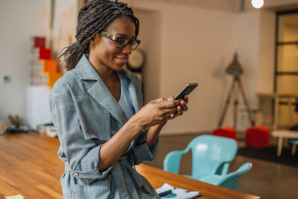 istock Young african woman with glasses using mobile phone 968373042