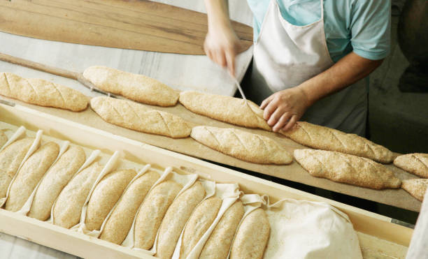 panettiere panificando il pane - cooked in a row traditional culture indoors foto e immagini stock