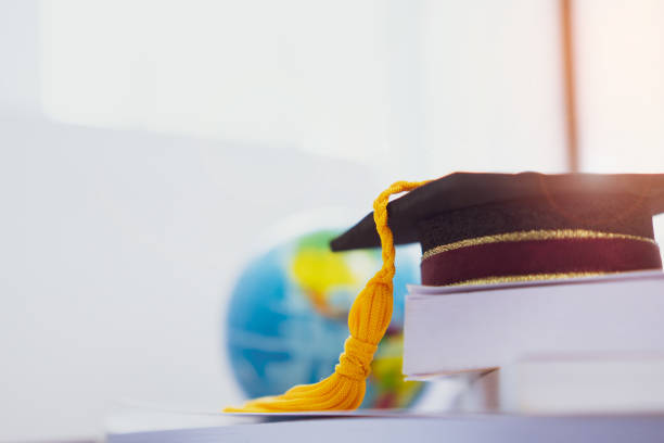 istock Graduated or Graduation university study abroad international Conceptual, Master cap on books stack with blur of america earth world globe model map in Library room of campus, Back to School 968377134