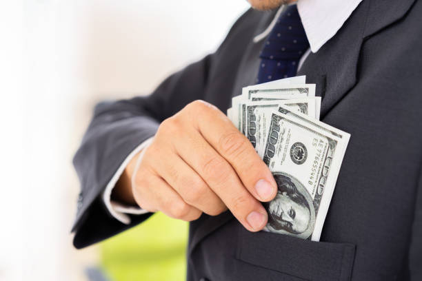 istock Businessman saving us dollar banknote to shirt pocket. 968379642