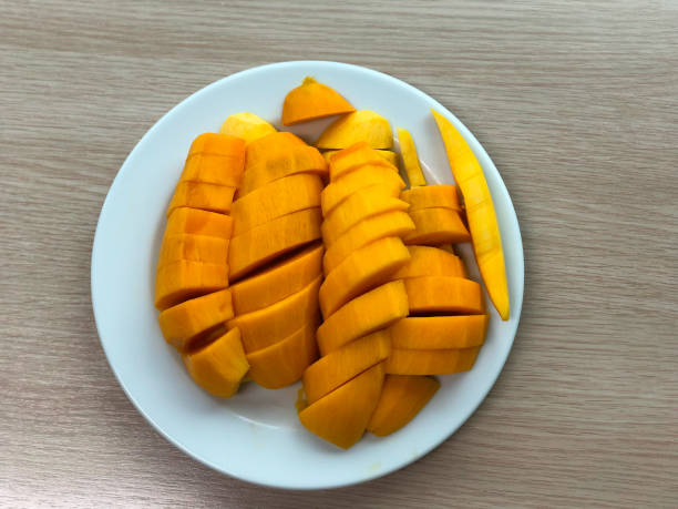 istock Yellow fresh mango pieces on white dish. Most popular and delicious Thai fruit 968384016